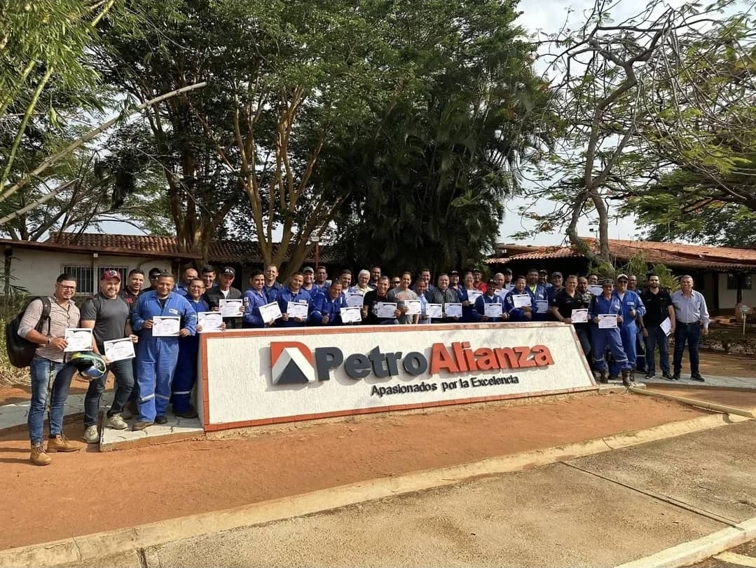 PetroAlianza team gathered with certificates in front of the corporate emblem